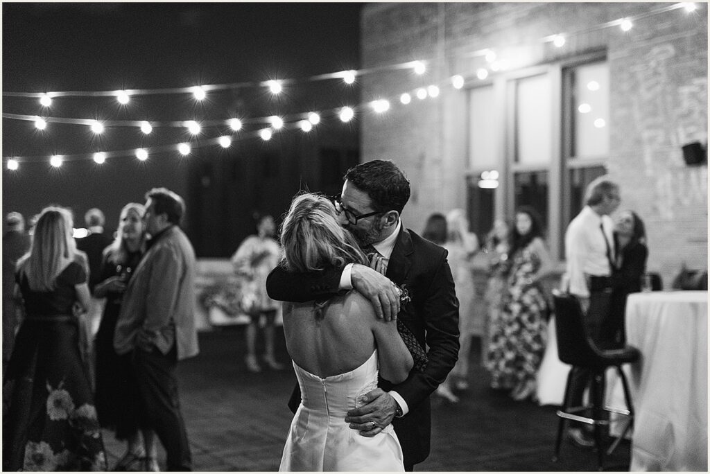 A groom kisses a bride's cheek at Irwin's Philly.